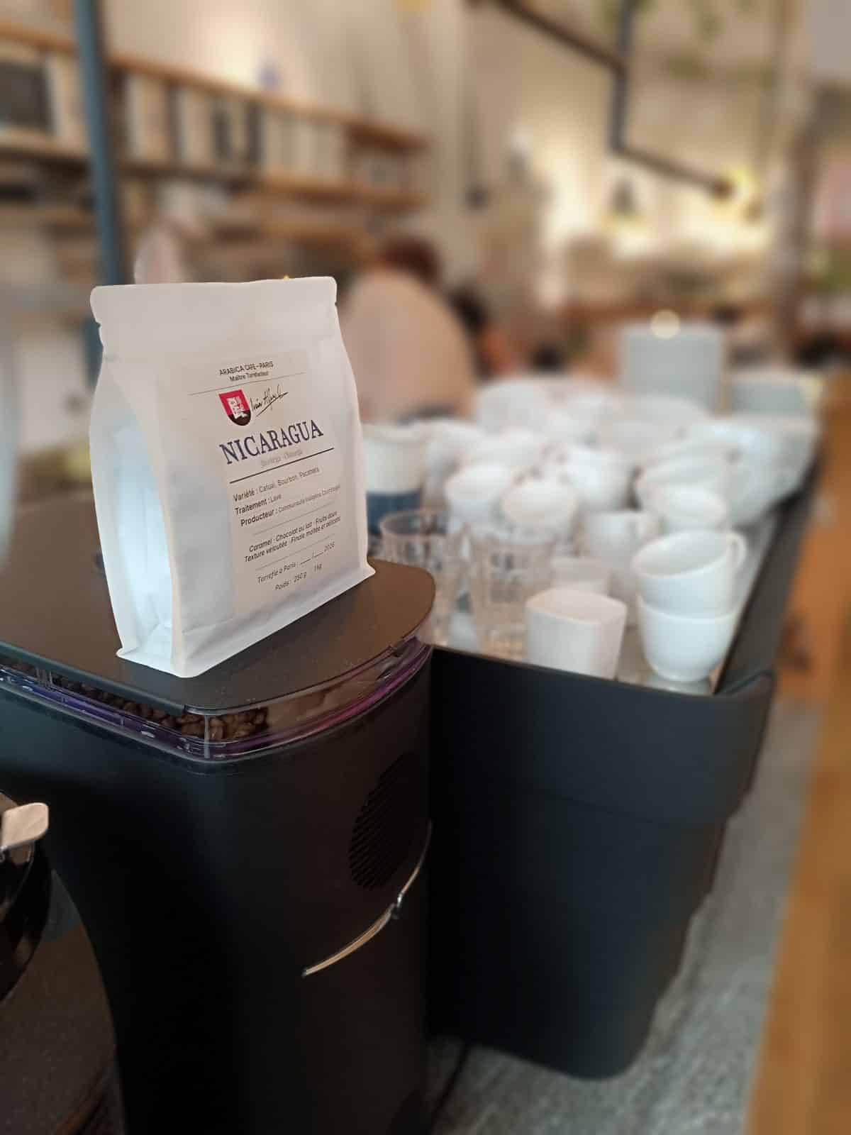 Sachet de café du jour posé sur le moulin du comptoir Cofftea
